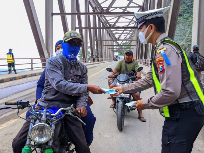 
 Satlantas Polres Lumajang Bagikan Masker Pasca Erupsi Semeru di Jembatan Besuk Kobokan